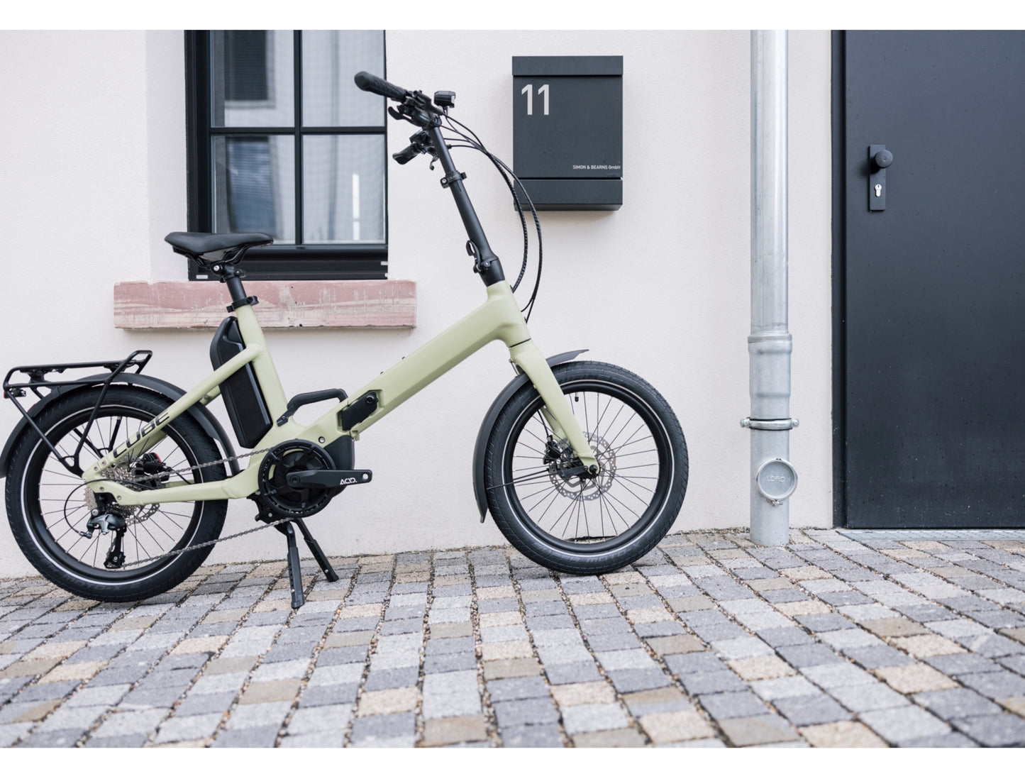 Cube Fold Sport Hybrid 500 electric bike green n black side profile business suite door in background