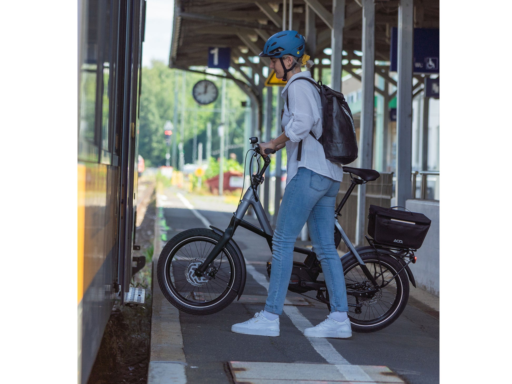 Cube Fold Sport Hybrid 500 electric bike woman boarding train with bike
