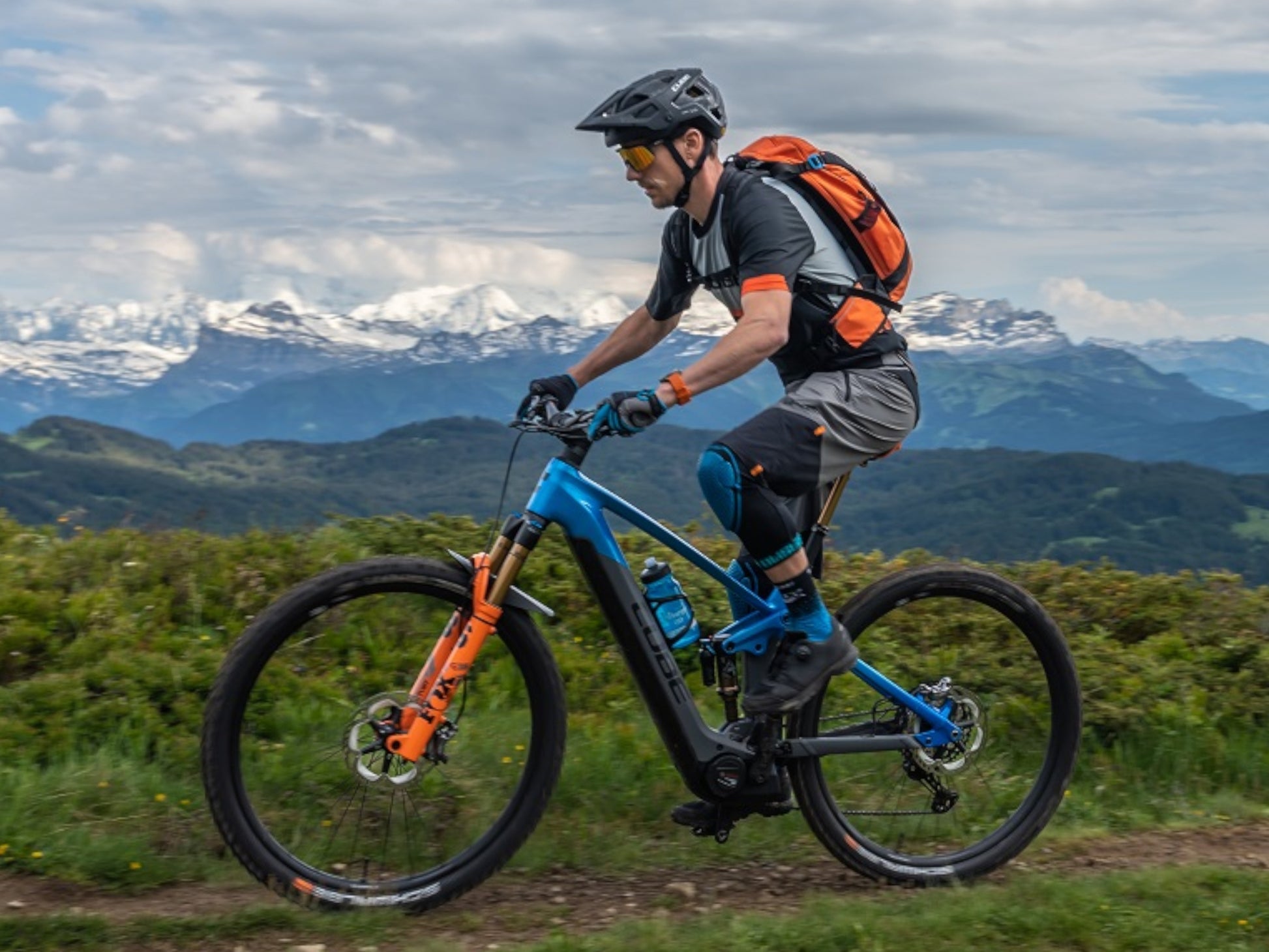 Cube Stereo Hybrid 140 HPC Actionteam 750 eMTB full Suspension man riding trail with mountains in the background