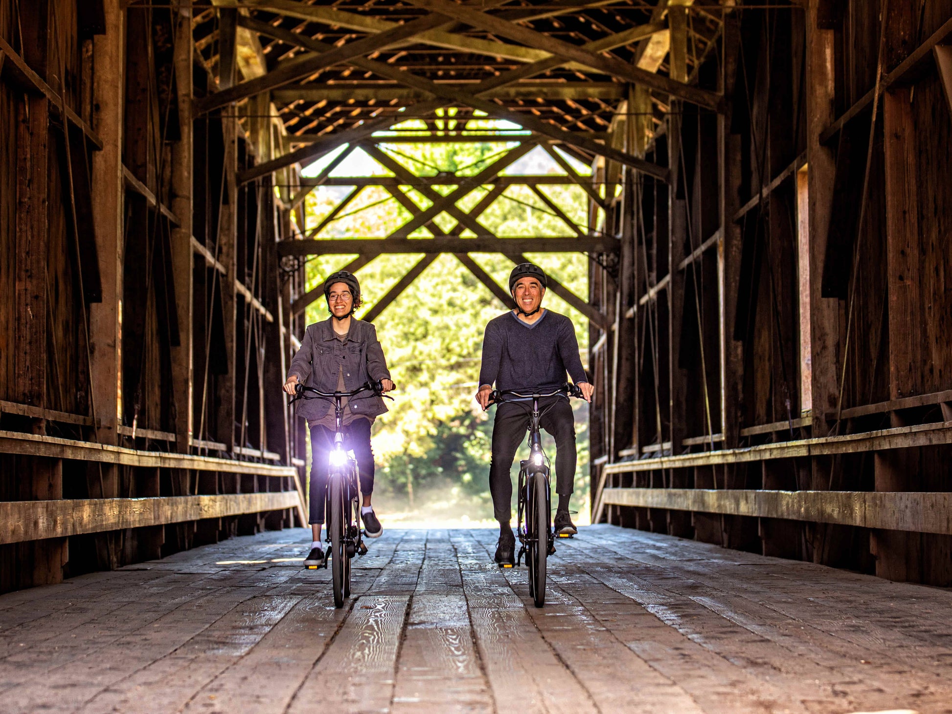 Gazelle Arroyo C7 emtb action photo couple riding covered bridge bike path