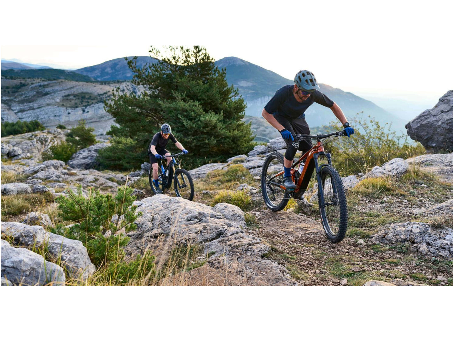 Giant Trance X E  + 2 Pro 29 eMTB full suspension two men riding up technical mountain single track.