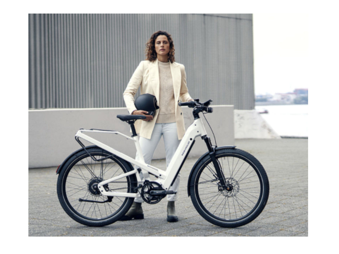 Riese and Muller Homage GT Rohloff HS ebike pearl white lady standing next to bike