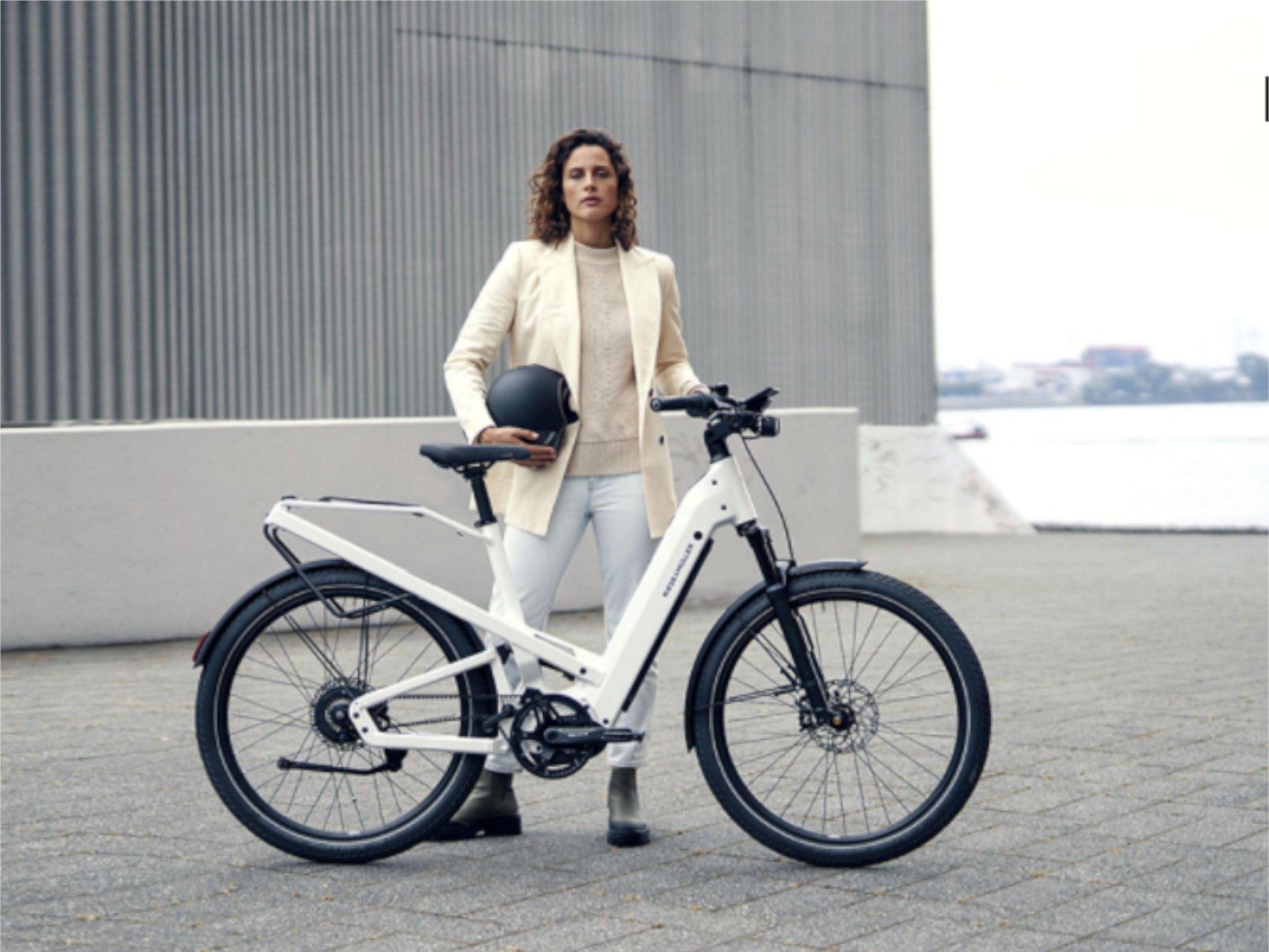 Riese and Muller Homage GT Touring HS ebike pearl white lady standing with bike