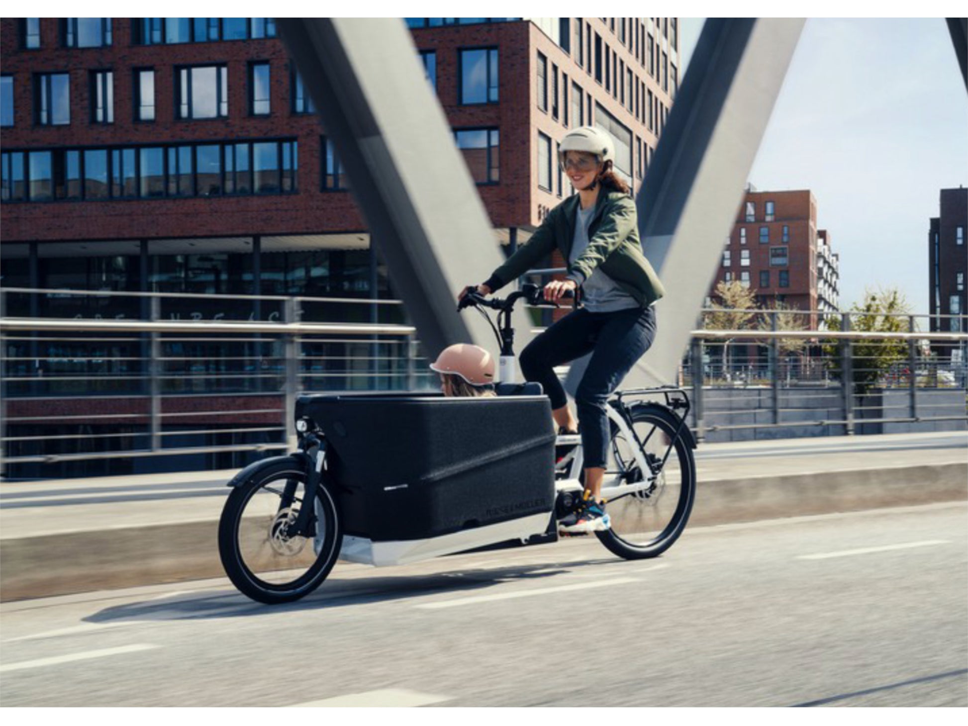 Riese & Muller Packster 70 Automatic cargo eMTB hardtail mother with child riding across bridge in city