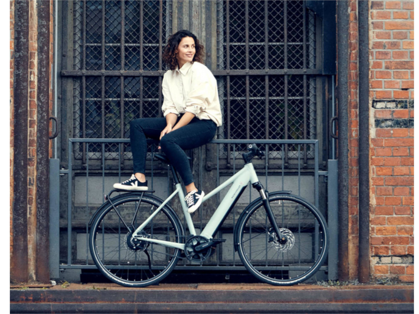 Riese and Muller Roadster Mixte Vario HS eMTB woman sitting with bike in city